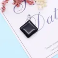 Polished black gemstone rhombus pendant with silver bail on decorative card background - 24x28mm / Black Agate