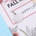 Polished apple-shaped white crystal pendant with silver metal bail on a floral card - White Crystal