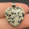Gepolijste hartvormige dalmatiër jaspis hanger met metalen oogje op een vinger - Dalmatijnse jaspis