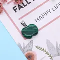 Polished malachite heart pendant with vibrant green stripes and silver metal clasp - Malachite
