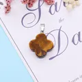 Macro detail of a tiger eye stone clover pendant with a silver metal clasp - Tiger's Eye