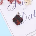 Detail of four-leaf flower stone pendant with red and black texture on white card - Swan Stone