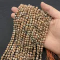 Faceted natural orange sunstone round beads held by hand for DIY jewelry making - Regular Stone / 6mm