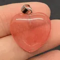 Roze aardbeienkwarts hartvormige hanger met zilveren sluiting getoond op een vinger - Watermeloen Kwarts