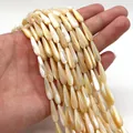 Detailed view of teardrop white mother of pearl shell beads held in hand for DIY jewelry - 4x7mm / Natural