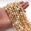Cuentas de concha natural irregular con brillo nacarado sostenidas en la mano - No.7 (Beige)