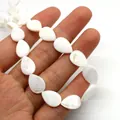 Natural white mother of pearl teardrop beads for DIY jewelry making held in hand - Teardrop