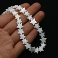 Macro shot of natural white star-shaped mother of pearl shell beads held in hand for scale - 6mm / White Shell