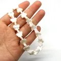 Makroaufnahme von Schmetterlingsperlen aus weißem Perlmutt für DIY-Schmuck - Schmetterling