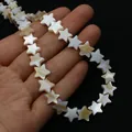 Macro shot of natural star-shaped mother of pearl shell beads held in palm on black background - 6mm / Brown