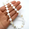 Detailansicht handgehaltener Kleeblatt-Perlen aus natürlichem weißem Perlmutt - Vierblättrige Blume