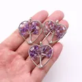 Detailed view of handmade heart-shaped tree of life pendants with purple natural stones - Amethyst