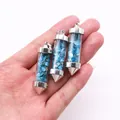 Detailopname van kogelvormige glazen hangers gevuld met helderblauwe natuurlijke stenen - 15x50mm / Apatiet