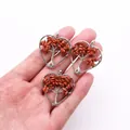 Detailed close-up of handmade heart-shaped Tree of Life pendants with red stone chips - Gold Sandstone
