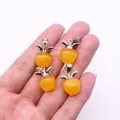Detailed view of four apple-shaped yellow cat eye stone pendants with silver leaf accents - Yellow Cat Eye Stone