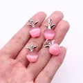 Nahaufnahme von vier rosa apfelförmigen Katzenaugenstein-Anhängern mit silbernen Blättern - Rosa Katzenauge