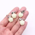 Natürlicher Opal-Apfelanhänger mit Silberblatt, in der Hand zur Größenbestimmung - Cremeweiß