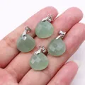 Macro view of four light green teardrop faceted stone pendants held in hand for detail - 16x17mm / Green Aventurine