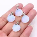 Faceted teardrop opal pendants with silver metal clasps held in hand - 16x17mm / Opal