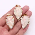 Tres colgantes de piedra natural blanca en forma de flecha con borde dorado - Piedra de Líneas Rojas
