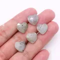 Colgantes de corazón facetado en labradorita gris con agujeros, sujetos en la mano - Piedra de Flash (Labradorita)