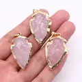 Main tenant trois pendentifs flèche en quartz rose avec bords dorés pour bijoux - Quartz rose