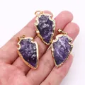 Trois pendentifs flèches en cristal violet avec élégante bordure plaquée or en main - Améthyste