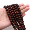Makroaufnahme von roten Tigeraugen-Perlen auf der Hand mit natürlichem Seidenglanz für DIY - 4mm Stil (10g) / Rotbraun (Nr.2)