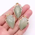 Trois pendentifs flèches en aventurine verte avec bord doré sur la paume d'une main - Jade Vert Clair Synthétique