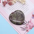 Detail eines herzförmigen polierten Unakit-Steins mit grünen und rosa Maserungen - Drachenblutstein