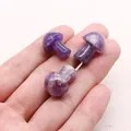 Close-up of three mini amethyst mushroom carvings held in hand showing scale and natural texture - Amethyst