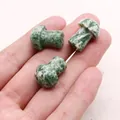 Close-up of three mini mushroom-shaped natural dragon blood stones held in a palm - Green Dot Stone