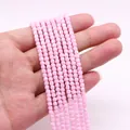 Vista macro de pequeñas cuentas cúbicas rosas para creación de joyería DIY y collares - Rosa
