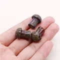 Close-up of polished mini mushroom stone carvings held in hand for size visualization - Dragon Blood Stone