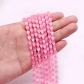 Macro detail of faceted pink cat eye stone teardrop beads held by hand for jewelry DIY - 4x6MM / Pink (Color 1)