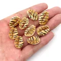 Detailed view of eight tiger-print cowrie shell beads for DIY jewelry held in hand - Orange Tiger (No. 8) / Pack of 20 (9x19mm)