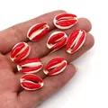 Detailed view of red and white natural cut conch shell beads held in palm for DIY jewelry - Red and White