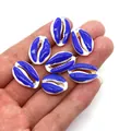 Royal blue natural cowrie shell beads in hand for DIY jewelry making size scale - Royal Blue and White