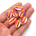 Macro detail of hand holding colorful gradient natural cowrie shell beads for DIY crafts - Size 6