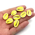 Macro view of eight yellow and white candy-colored shell beads held by a hand - Yellow and White