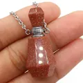 Macro shot of Goldstone perfume bottle pendant necklace with glittering metallic luster - 25x38mm / Gold Sandstone