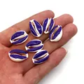 Purple and white natural seashell beads for DIY jewelry held in hand for scale - Purple and White