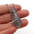 Macro shot of a hexagonal crystal perfume bottle pendant held by hand on white background - Purple Fluorite