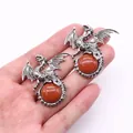Detail of silver-plated dragon pendant featuring a polished red sandstone bead inlay - 43x43mm / Gold Sandstone