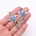 Detail of silver angel wing key pendants with blue marble stones held in hand - Blue Spot Stone