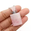 Detail of hand-held pink crystal perfume bottle pendant necklace with silver screw cap - 19x37mm / Rose Quartz