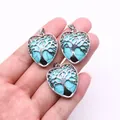 Detailed view of three heart-shaped pendants with Tree of Life engraving and green stone - Blue Turquoise