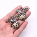 Detail showing hand holding silver Viking dragon pendants with dalmatian jasper stones - 43x43mm / Dalmatian Jasper