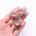 Close-up of heart-shaped Life Tree pendants with red natural stone and silver alloy detail - Watermelon Quartz