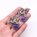 Detail of silver viking dragon pendants holding purple round gemstones held by hand - 43x43mm / Purple Crystal